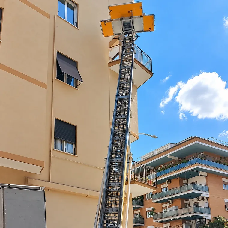 L'autoscala montata accanto a un palazzo per raggiungere i piani alti