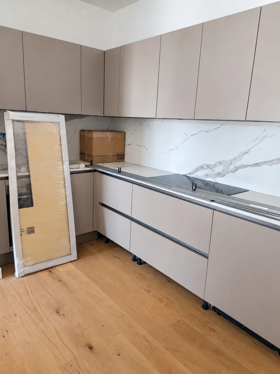 Cucina moderna grigia rimontata, con il piano in marmo bianco